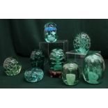 Green coloured glass paperweights including bubble and floral inclusions (8)