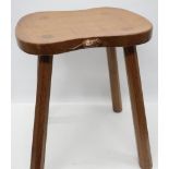 Robert Mouseman Thompson - an oak Cow stool, shaped rectangular adzed top on four out splayed