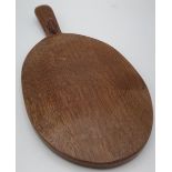 Robert Mouseman Thompson - an adzed oak oval cheeseboard, handle carved with signature mouse L37cm