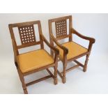Robert Mouseman Thompson - a pair of oak elbow chairs with lattice carved backs and brass nail