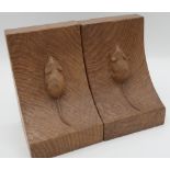 Robert Mouseman Thompson - a pair of adzed oak book ends of curved form, carved with signature mouse