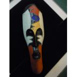 A tribal mask with elongated face and coloured decoration approx 50cm long