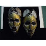 A pair of African tribal masks with engraving to the hairpiece and painted gold faces approx 43cm