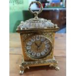 Cast gilt metal mantel clock, cartouche dial and carry loop on four paw feet H24cm