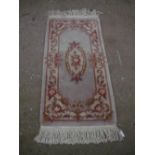 Chinese washed woollen rug, beige ground with central floral pattern and floral patterned border,
