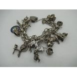 Sterling silver charm bracelet with various charms including animals, Queens Silver Jubilee,