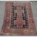 C20th Caucasian pattern rug, two medallions on blue ground geometric patterned border surrounded