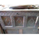 Early C18th oak blanket box with three panel top and lozenge carved panel front with rosette frame