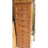 Contemporary pine finished tall chest of ten tapering drawers with metal ring handles on bracket