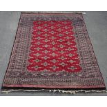 C20th Caucasian pattern wool rug with red ground with patterned centre set with geometric motifs