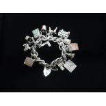 Silver charm bracelet with heart padlock clasp , charms include £1 and £10 notes, London bus, Big