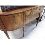 Regency mahogany bow break front sideboard, decorated with ebonised stringing, on ring turned