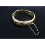 9ct gold hinged bangle with safety chain stamped 9ct 25.3g