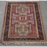 C20th Caucasian patterned rug with central medallion, green and burnt orange ground geometric blue