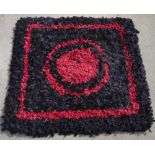 Mid C20th 'Clippy' type rug, blue and black ground with central red roundel and borders, 90cm x 90cm