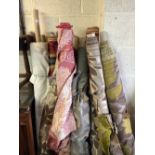 22 rolls of curtaining fabric in various patterns and prints