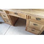 Pine writing desk with rectangular top over nine drawers with turned wooden handles (122cm x 80cm