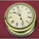 C20th brass cased bulk head ships time piece, hinged bezel enclosing cream painted dial with Roman