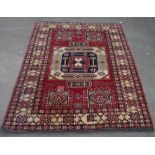C20th Caucasian pattern wool rug, central beige ground patterned medallion surrounded by red field