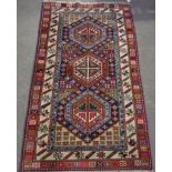 C20th Caucasian pattern rug, three central hexagonal medallions, surrounded by geometric patterned