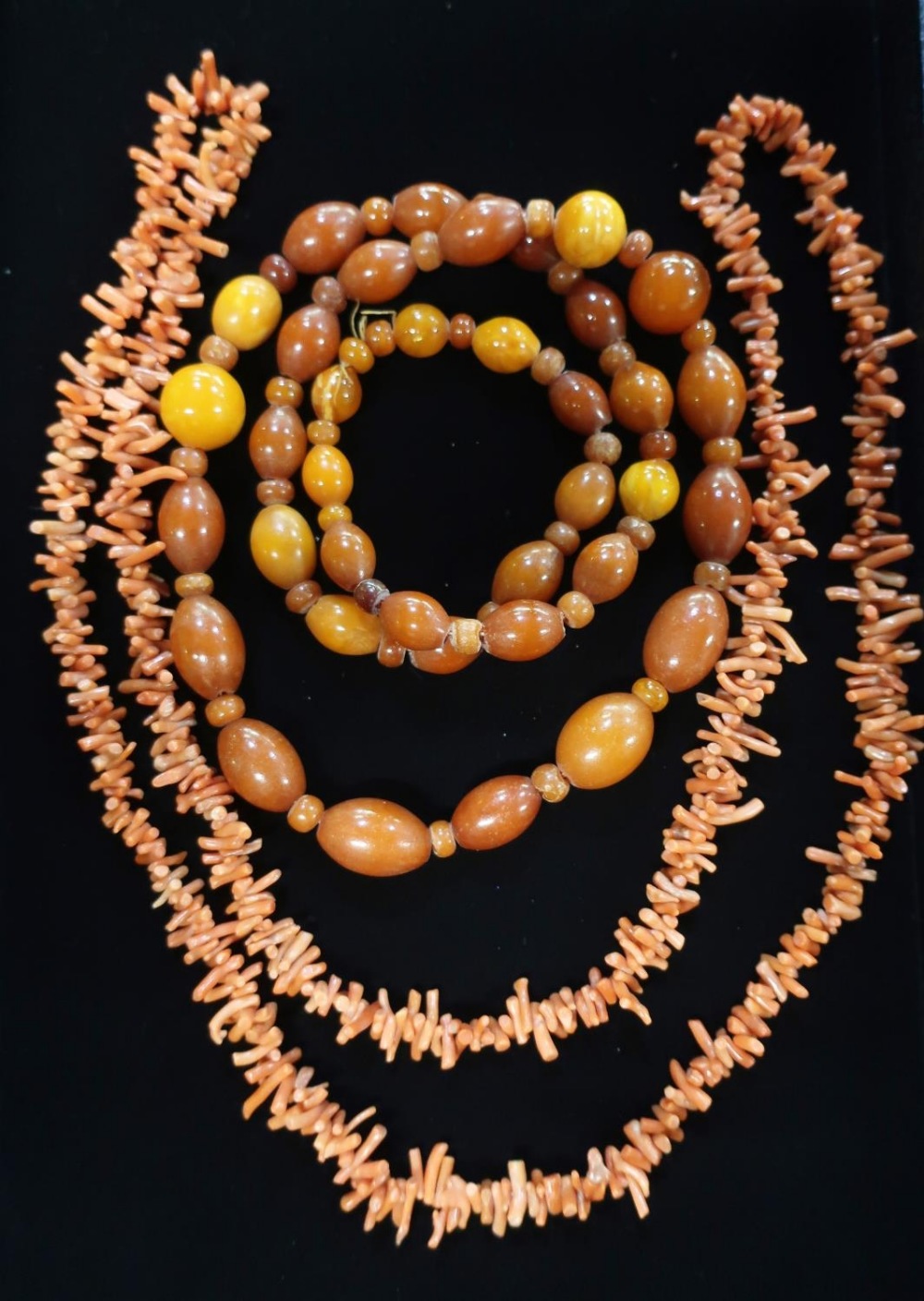 Graduated butterscotch amber beaded necklace L80cm 69.6g and a Coral necklace in a painted red box