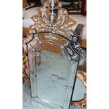 Venetian style wall mirror, segmented arched plate decorated with foliage, and with pierced urn