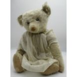 Early C20th teddy bear in long white mohair with flat button eyes shaved muzzle jointed arms and