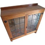 Robert Mouseman Thompson - an oak display cabinet, low raised back with adzed top above a pair of