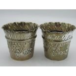 Pair of Victorian hallmarked silver beakers, cylindrical bodies with waved rims, repousse with