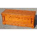 Modern pine rectangular blanket box with paneled front, hinged lid and bracket feet. W134cm D47cm