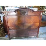 Continental walnut double bedstead, arched headboard carved with flower basket, footboard with