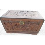 C20th Chinese camphor lined blanket box, hinged top and front with deep carved with figures in a