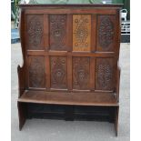 C19th oak tavern type settle with lozenge and oval carved eight panel back, above shaped seat,