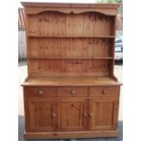 Pine farmhouse dresser, twin shelf back above three drawers and three cupboard doors, on plinth base