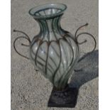 Large Urn shaped brass vase in metal strapwork support on similar square base. H76cm