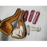C20th cased Meerschaum pipe carved with a gundog, simulated amber mouthpiece, three Victorinox "