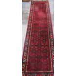Eastern multi coloured runner, with geometric design within a repeating stylized border, W75cm