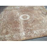 C20th Chinese embossed washed woollen rug, old gold ground with central floral pattern medallion