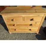 Pine chest of two short and two long drawers with turned wooden handles and feet