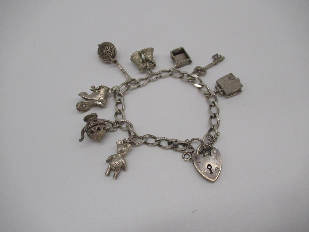 Sterling silver charm bracelet including charms of Holy Bible, warming pan, boot, teddy etc with