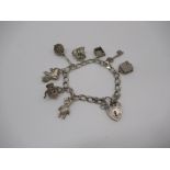 Sterling silver charm bracelet including charms of Holy Bible, warming pan, boot, teddy etc with