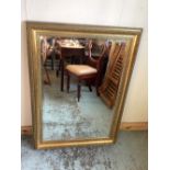 Wall mirror, rectangular bevelled plate in gilt moulded scroll frame