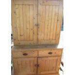 Pine side cabinet, twin planked doors above two drawers and two similar doors on a plinth base,