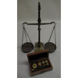 C20th brass apothecary scales, cast tapering centre column on shaped base with integral weights, and