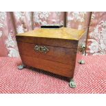 C19th oak sarcophagus shaped two division tea caddy, with brass cartouche, handle and paw feet,