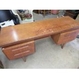 1970's G Plan teak dressing table with pull-out slide and recessed well flanked by two drawers on