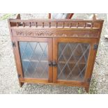 Late c20th oak wall cabinet with gallery carved decoration, two leaded glazed panel doors