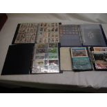 Four albums of cigarette cards postcards coins etc