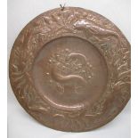 C20th Newlyn style circular copper charger, repousse decorated with fish and in seaweed border,