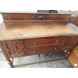 C20th dark oak sideboard with two drawers and two doors with carved oval details, on supports with